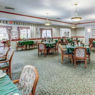 A formal dining room with neatly arranged tables and chairs, ready for guests.