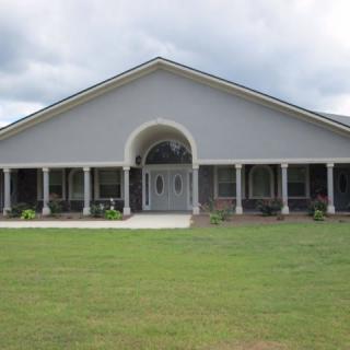 A single-story house with a wide porch and front lawn.