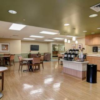 A spacious and modern cafe interior with seating and a coffee station.