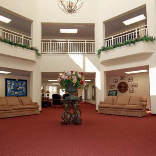 A spacious lobby with comfortable sofas and elegant decor, featuring a central floral arrangement.