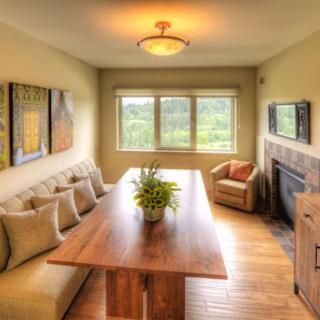 A cozy dining area featuring a wooden table, comfortable seating, and a beautiful view of the outdoors.
