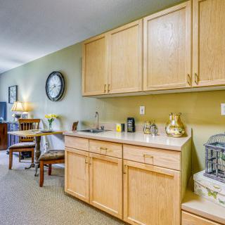 A cozy kitchenette with wooden cabinets and a small dining area.