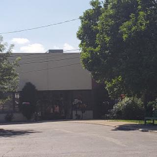 A view of a building surrounded by greenery on a sunny day.