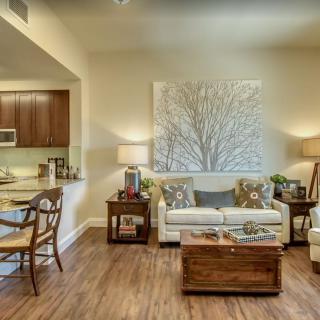 A cozy and modern living room with a neutral color palette, featuring a sofa, coffee table, and decorative wall art.