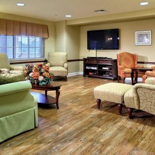 A cozy living room with comfortable seating, a television, and a wooden floor.