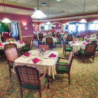 An elegantly furnished dining area in a restaurant with neatly arranged tables and chairs.