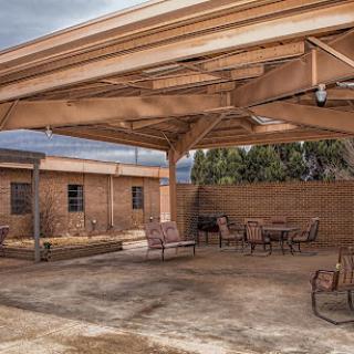A spacious outdoor patio area featuring a covered seating arrangement, perfect for relaxation.