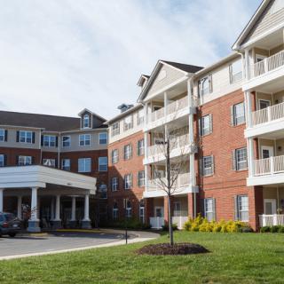 A multi-story residential apartment building with a brick exterior and balconies.