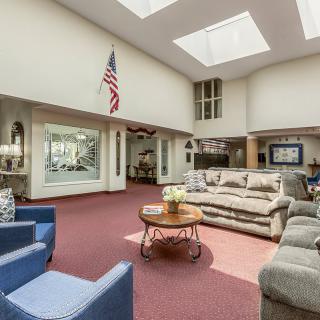 A spacious lobby area featuring comfortable seating, skylights, and an American flag.