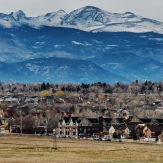 A picturesque town nestled at the foot of snow-capped mountains.