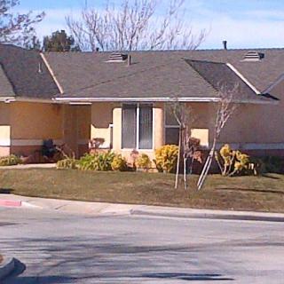 A single-story suburban house with a well-maintained front yard and driveway.