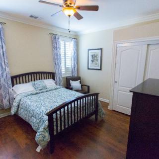 Cozy bedroom with a wooden bed and ceiling fan.