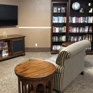A cozy living room with bookshelves, a sofa, and a television.
