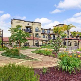 A modern building surrounded by landscaped gardens and pathways.