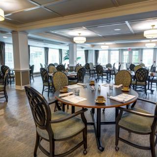 An elegant, empty dining room with neatly arranged tables and chairs.