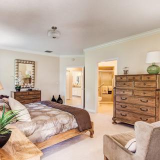 A cozy bedroom with warm wood furniture and neutral tones.