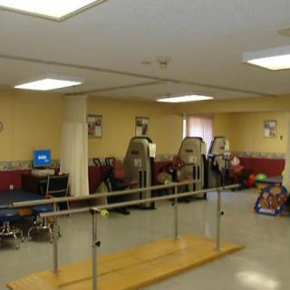 A rehabilitation room with therapy equipment and exercise machines.