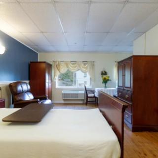 A cozy bedroom with wooden furniture and ample natural light.