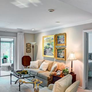 A cozy living room with a sofa, artwork, and elegant decor.