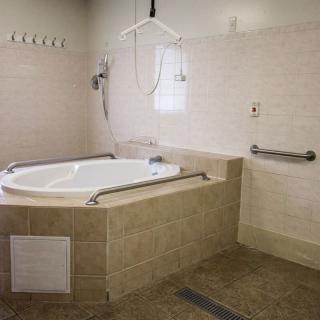 An accessible bathroom with a whirlpool bathtub and handrails.