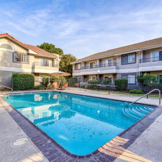 A sunny day at an apartment complex with a clean outdoor swimming pool.