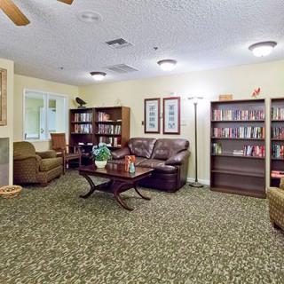 A cozy living room with bookshelves, comfortable seating, and a coffee table.