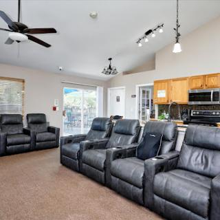 A cozy living room featuring reclining chairs and an open kitchen space.