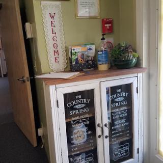 A welcoming entryway featuring a charming cabinet and a cheerful 'Welcome' sign.