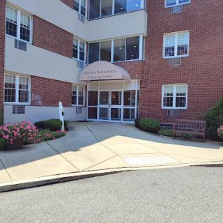 A view of the entrance to a brick building with a landscaped area.