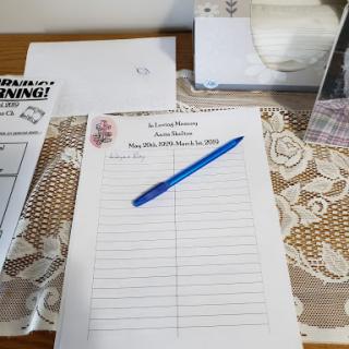 A notepad and pen set up for writing, resting on a decorative table surface.