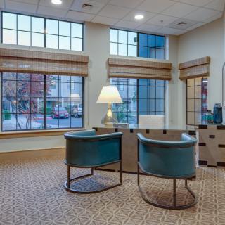 A cozy office waiting area with modern chairs and large windows.