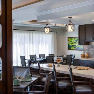 A modern dining room with elegant lighting and spacious seating.
