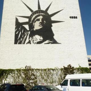 A mural of the Statue of Liberty on a building facade.