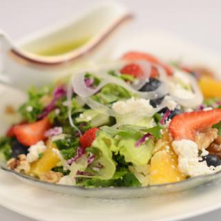 A vibrant, fresh salad with a mix of colorful vegetables and fruits.