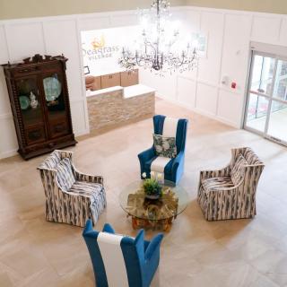 A modern living room with elegant seating and a chandelier.