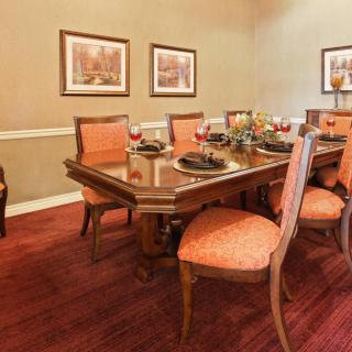 A well-decorated dining room with a large table and upholstered chairs.