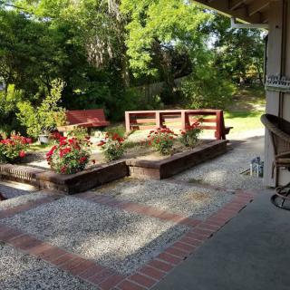 A serene garden patio with flowering plants and brick accents.