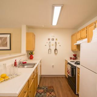 A cozy kitchen with wooden cabinets, modern appliances, and decorative touches.