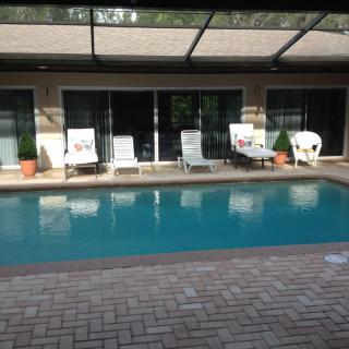 A serene backyard with a swimming pool and comfortable outdoor seating.