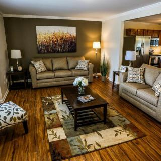 A cozy living room with two sofas, a central coffee table, and warm lighting.