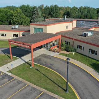 Aerial view of a modern facility with a welcoming entrance and ample parking.