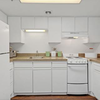 A modern kitchen with white cabinets and appliances.