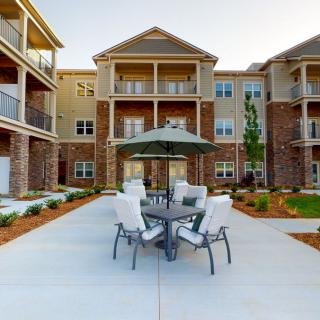 Modern apartment building with a furnished outdoor patio area.