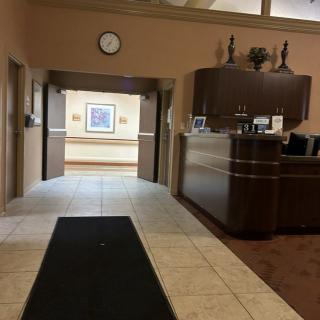 A view of an office reception area with a desk and open hallway.