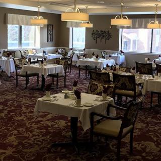 An elegantly decorated dining room with neatly arranged tables and chairs, ready for guests.
