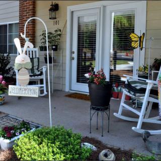 Cozy front porch with rocking chair and garden decorations.