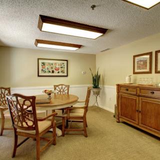 A cozy dining room featuring a wooden table, chairs, and decorative elements.