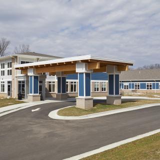 A modern building with a covered entrance and driveway.