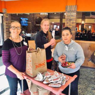 A group of people serving food in a restaurant setting.