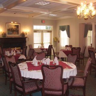 An elegant dining room with neatly arranged tables and a chandelier.